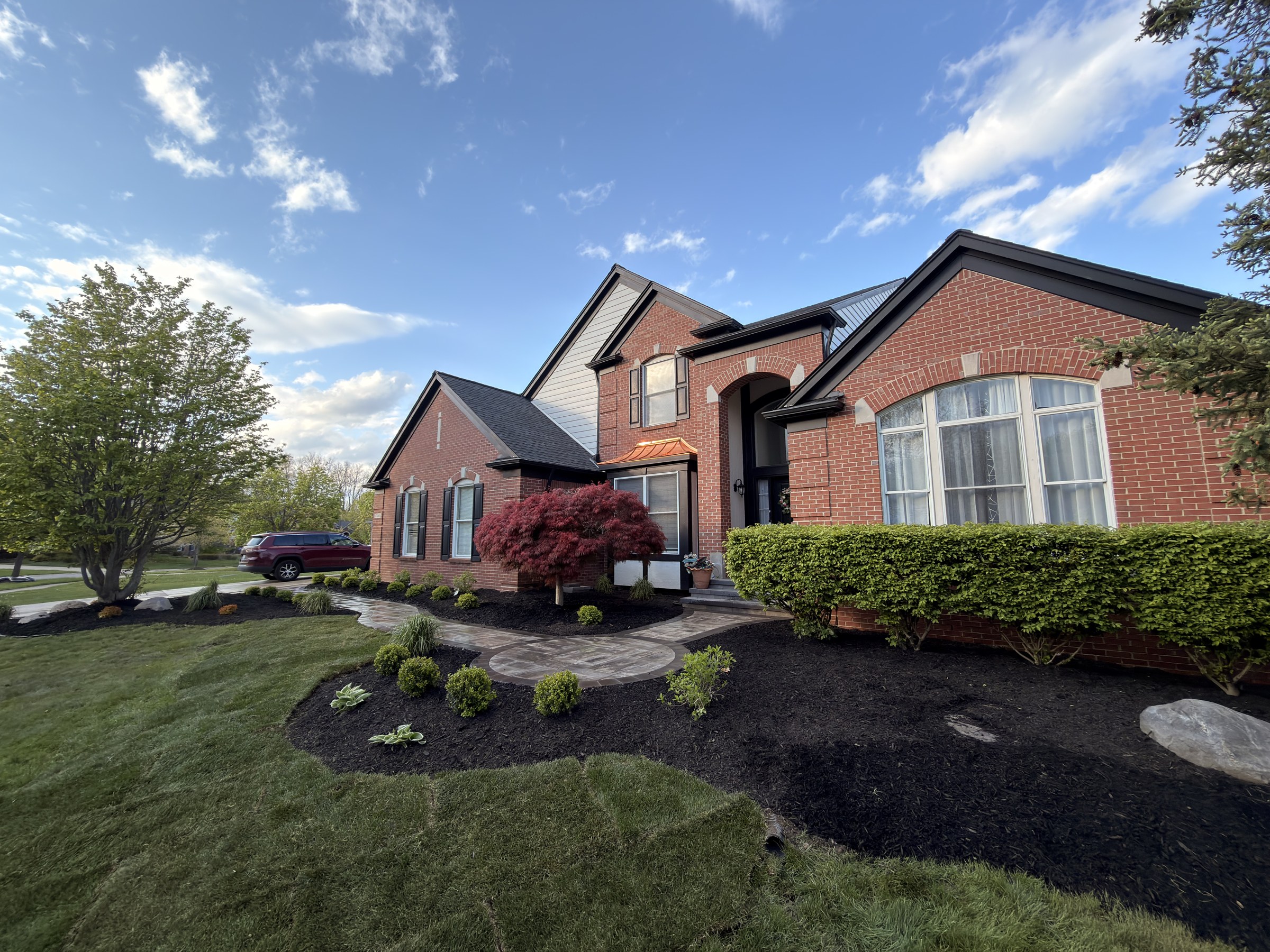 Brick home with new mulch beds and paver walkway landscape design