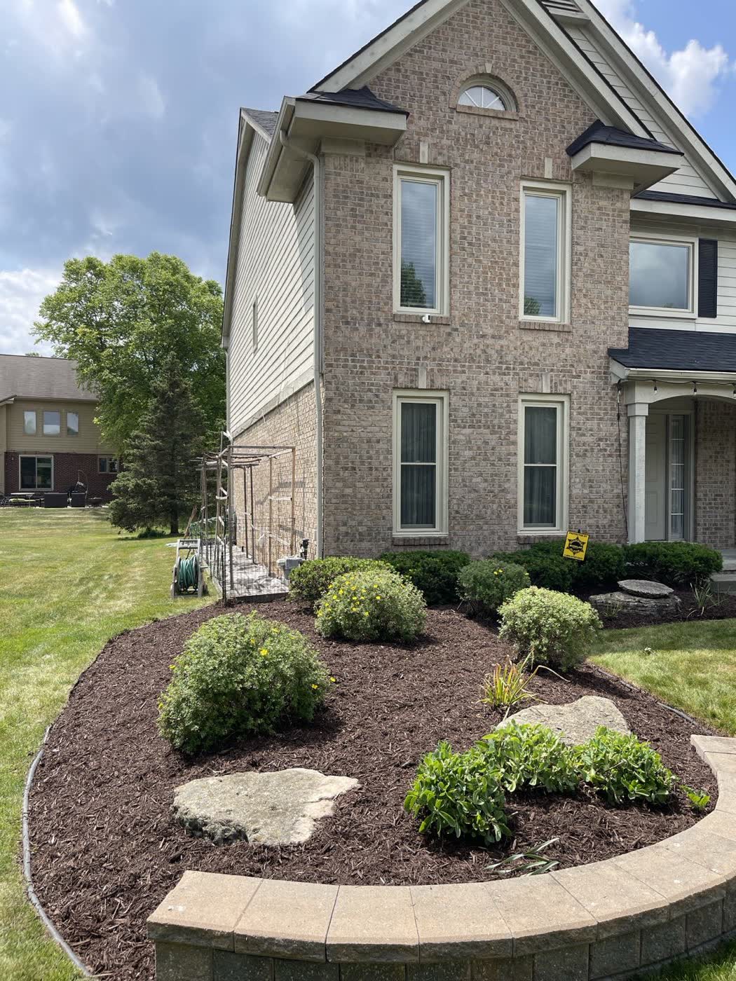 Front bed with stepping stones, mixed plantings and a clean cut edge